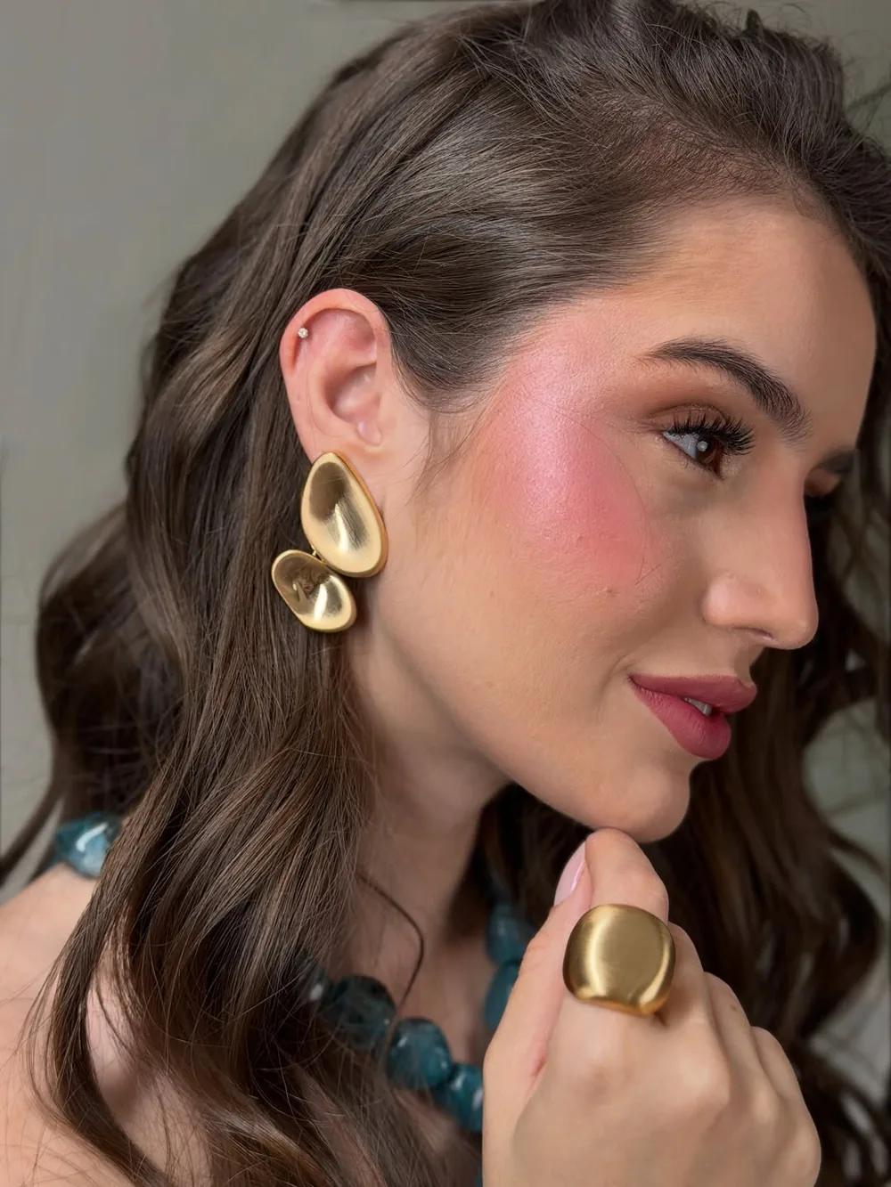 Detalhe de brinco dourado e colar da Coleção Soirée